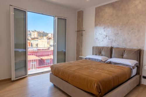 a bedroom with a large bed and a large window at NA bella vista Rooftop-B&B in Naples