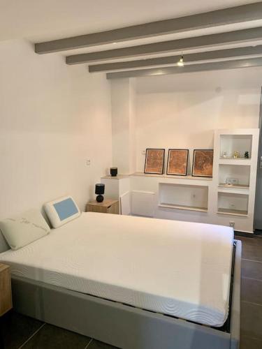 une chambre avec un grand lit blanc dans une pièce dans l'établissement Le Loft Provençal, au Thor