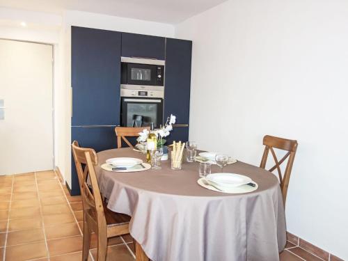 une table de salle à manger avec des assiettes et des verres dessus dans l'établissement Apartment Catalona by Interhome, à Saint Cyprien Plage