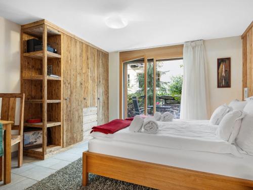 een slaapkamer met een groot bed en een raam bij Apartment Rütschi-1 by Interhome in Zermatt