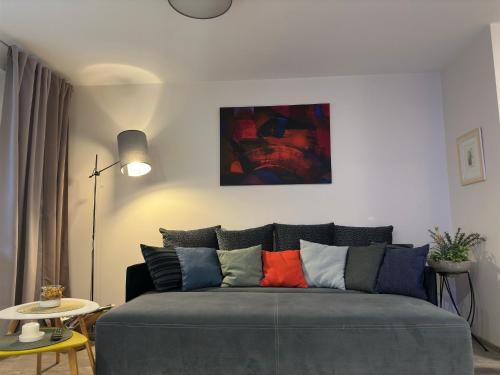 a couch with colorful pillows in a living room at Smiltės apartamentai in Birštonas