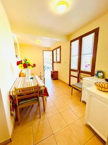 a kitchen with a table and chairs in a room at Maison charmante avec vue sur la mer et montagnes, Les Anses-d'Arlet. in Les Anses-dʼArlets