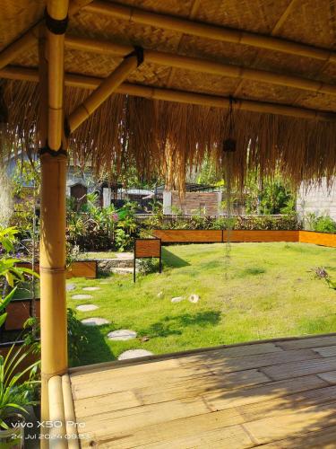a view of a yard with a grass roof at The hidden cliff of North Bali in Sukasada