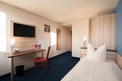 a hotel room with a bed and a desk at Motel 44 in Geseke