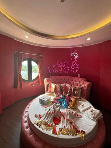 a bedroom with a bed with a pink wall at King Bavi Resort in Ba Vì