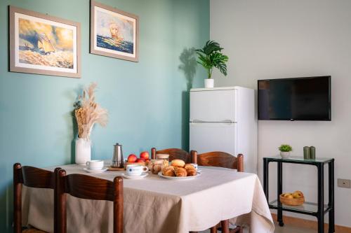 a table with a white table cloth and a white refrigerator at Club del Sole Stork Family Collection in Giulianova
