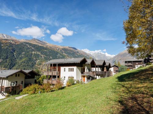 a group of buildings on a hill with mountains in the background at Apartment Aragon B47 by Interhome in Ernen