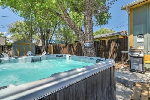 a hot tub in a backyard with a tree at The Vibrant Victorian Hot Tub & Fire Pit in OCC in Colorado Springs
