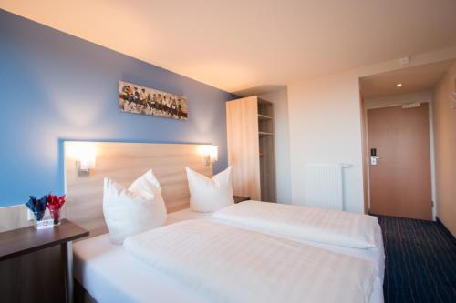 a hotel room with two beds with white pillows at Motel 44 in Geseke