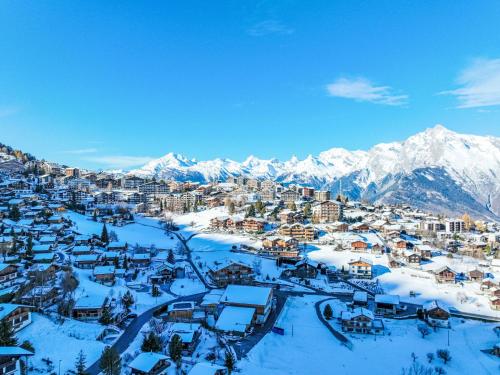a city covered in snow with mountains in the background at Apartment Clair Matin 20 by Interhome in Nendaz