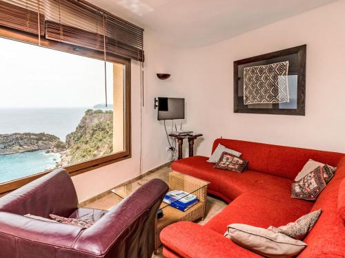 salon z czerwoną kanapą i oknem w obiekcie Holiday Home Igor by Interhome w mieście Balcon del Mar
