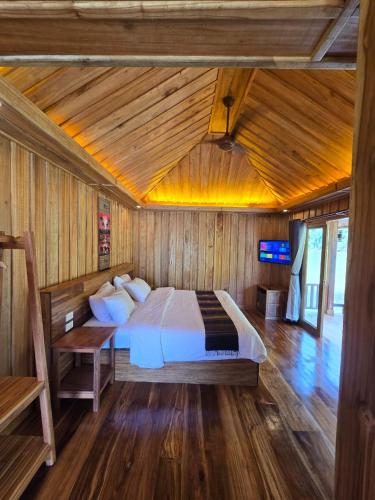 a bedroom with a bed in a wooden room at Nongkhiaw The Float House in Nongkhiaw
