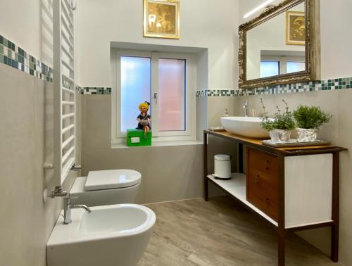 a bathroom with a sink toilet and a mirror at Casa Hygge Argegno Lago di Como in Argegno