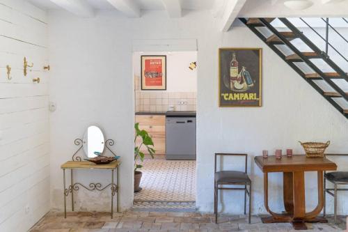 une cuisine avec une table et un évier, ainsi qu'un escalier. dans l'établissement Gîte de campagne calme et moderne, à La Chapelle-sur-Loire