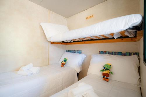 two beds in a room with two bunk beds at Club del Sole Stork Family Collection in Giulianova