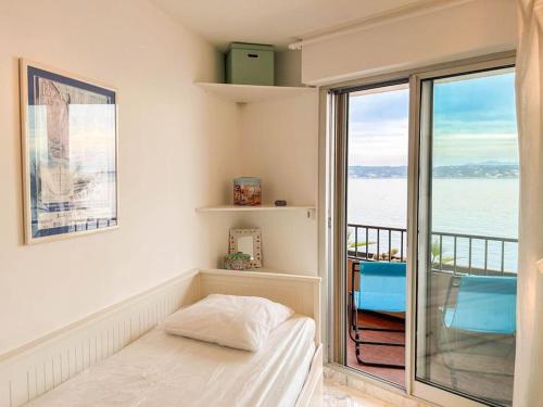 une chambre avec un lit et une vue sur l'océan dans l'établissement T3 Bandol vue mer - Les pieds dans l'eau, à Bandol