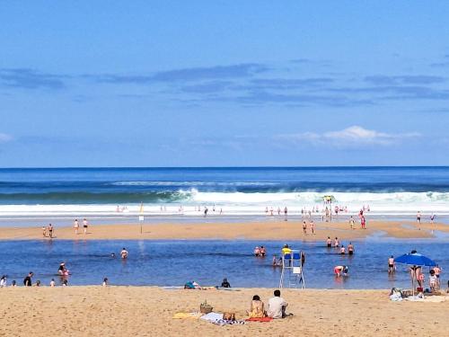 a group of people in the water at a beach at Apartment Capama-1 by Interhome in Mimizan-Plage