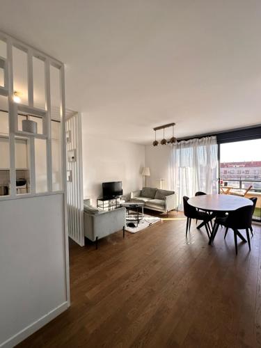 un salon avec une table et un canapé dans l'établissement Le Central, à Colombes