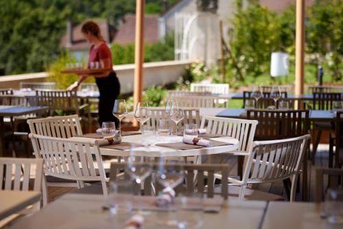 a woman standing in front of a table with wine glasses at Prosper Maufoux - Château de Saint-Aubin in Saint-Aubin