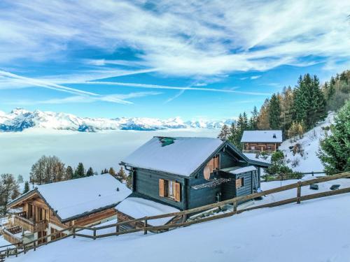 a cabin in the snow with a lake and mountains at Chalet Le Ruisseau by Interhome in Nendaz