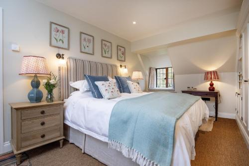 Un dormitorio con una cama grande y dos lámparas. en Jerards Stables, en Sherborne