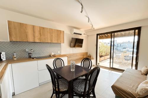 une cuisine et une salle à manger avec une table et des chaises dans l'établissement Renovated 2 room apartment - AC and terrace, à Grimaud