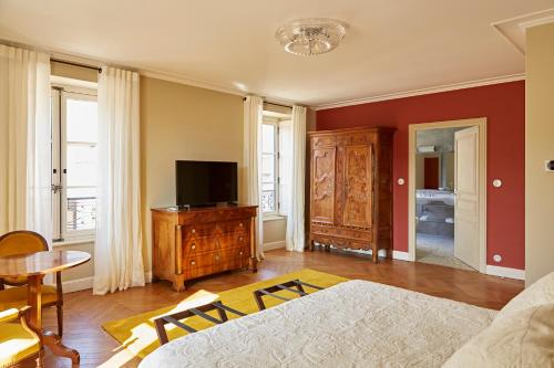 a living room with a couch and a tv at Prosper Maufoux - Château de Saint-Aubin in Saint-Aubin