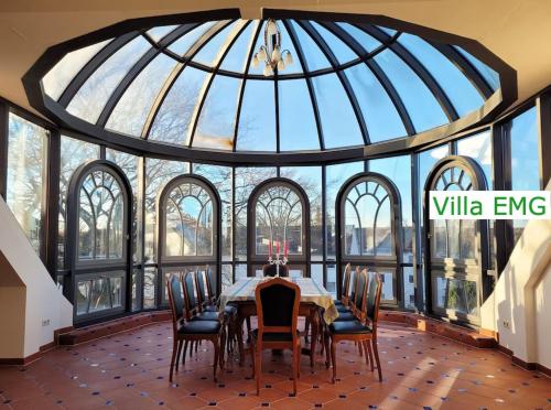 a dining room with a glass ceiling with a table and chairs at Luxus Stadtvilla EMG Hannover Braunschweig Wolfsburg 20P in Lehrte