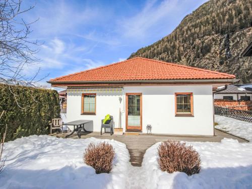 a small white house with a table in the snow at Holiday Home Margret by Interhome in Längenfeld