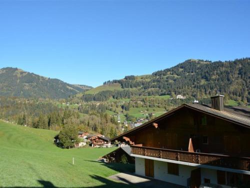a house on a hill with mountains in the background at Apartment Hornflue - Wohlwender by Interhome in Gstaad