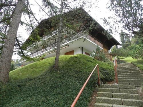 a building on a hill with stairs in front at Apartment Hornflue - Wohlwender by Interhome in Gstaad