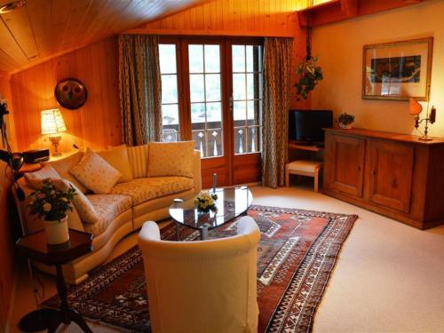 a living room with a couch and a table at Apartment Hornflue - Wohlwender by Interhome in Gstaad