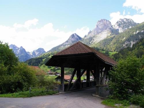 a wooden pavilion with mountains in the background at Apartment Adlemsried by Interhome in Boltigen