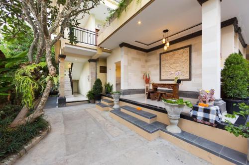 a courtyard of a house with a bench and a table at The Tunjung Ubud Retreat in Ubud