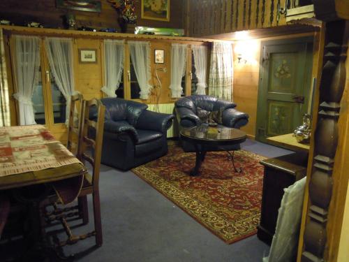a living room with a leather chair and a table at Apartment Le Vieux Chalet by Interhome in Gstaad