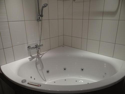 a bath tub with a shower in a bathroom at Apartment Dorfstrasse 7-42 by Interhome in Engelberg
