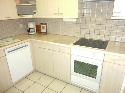 a kitchen with white cabinets and a sink at Apartment Blumenweg 8 by Interhome in Engelberg