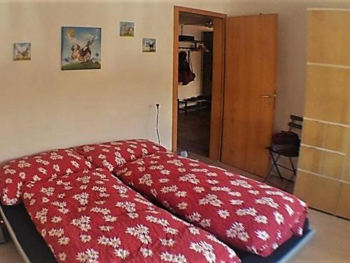 a bedroom with a red comforter on a bed at Apartment Kronenplatz 7 # 3 by Interhome in Lenk