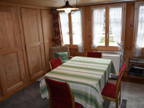 a room with a table and chairs and windows at Apartment Mittaghorn by Interhome in Gsteig