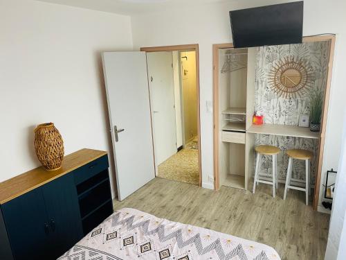 - une chambre avec un miroir et un placard avec des tabourets dans l'établissement Studio centre-ville République, à Dijon