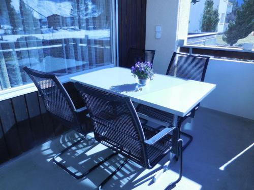 a white table and chairs with a potted plant on it at Apartment Sunnmatt Süd 412 by Interhome in Engelberg