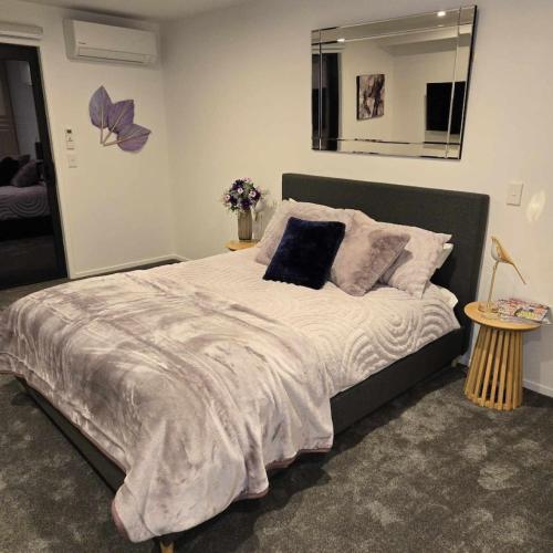 a bedroom with a large bed with a mirror at Pats CBD Studio in Christchurch