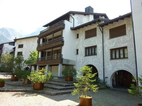 a building with potted trees in front of it at Apartment Am Dürrbach 4-413 by Interhome in Engelberg