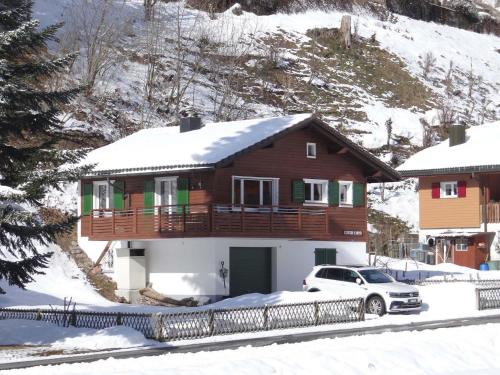a house in the snow with a car parked in front at Apartment Casa Mira by Interhome in Engelberg