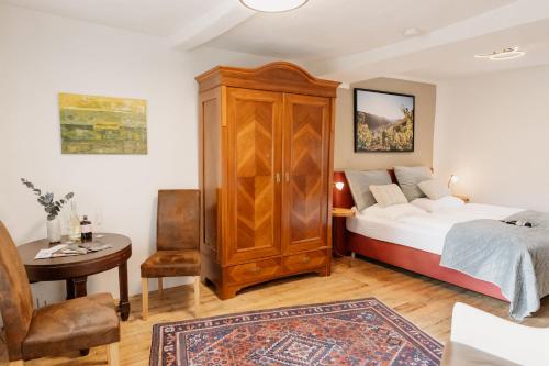 Un dormitorio con una cama, un armario y una mesa. en Eulenhaus, en Ediger-Eller