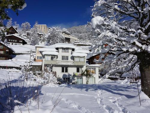 a house in the snow with snow covered trees at Apartment Bergfried by Interhome in Engelberg