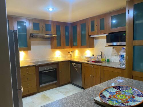 a kitchen with wooden cabinets and a counter top at Sunset & Boat Watching Balcony SOL-QR-LTL-2025- 00508 in Puerto Aventuras