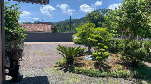 a garden with trees and plants in a yard at Cantinho da Tia Dori in Rio Forcação