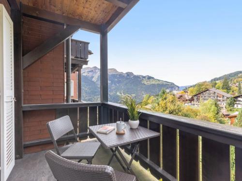 a balcony with a table and chairs and mountains at Apartment Bristol Apt-S by Interhome in Wengen