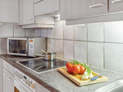 a kitchen with a counter with tomatoes on a cutting board at Apartment Bristol Apt-18 by Interhome in Wengen